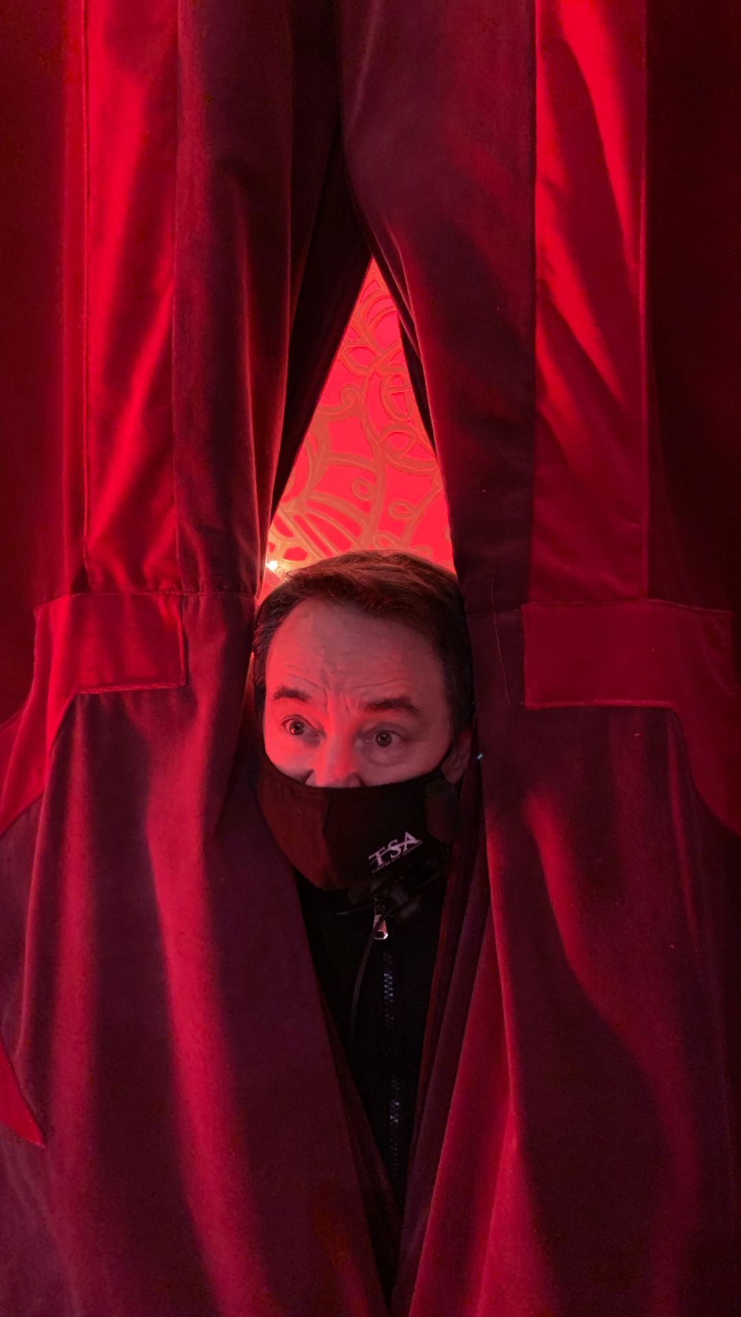 RM popping head through red curtain MRTM