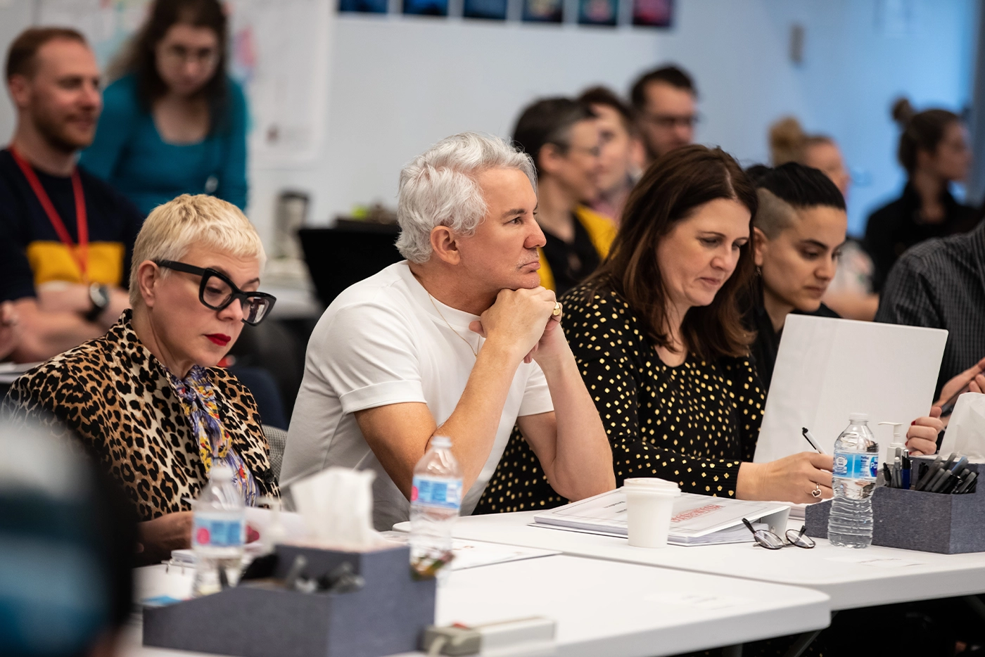 Catherine Martin, Baz Luhrmann, Carmen Pavlovic, and Sonya Tayeh sitting at a table during rehearsals of Moulin Rouge! The Musical