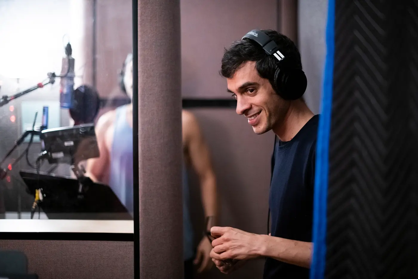 Justin Levine, Music Supervisor, Orchestrator, Arrangements & Additional Lyrics of Moulin Rouge! The Musical, inside a recording booth with headphones on