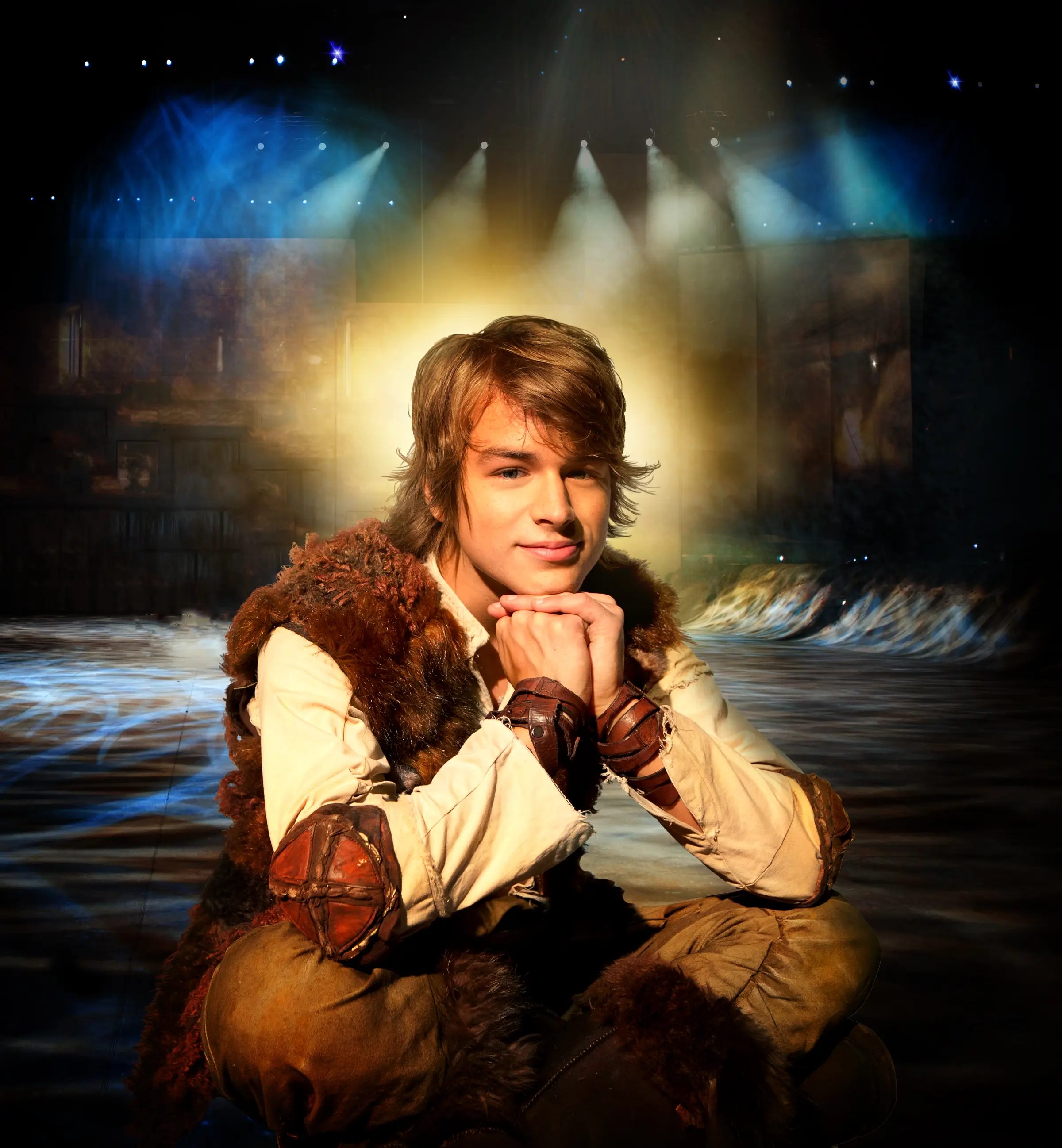 Hiccup sitting cross legged with elbows on knees and hands under his chin