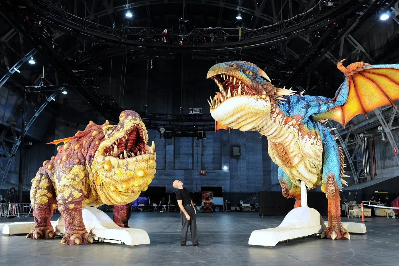 Man standing beside the dragon puppets
