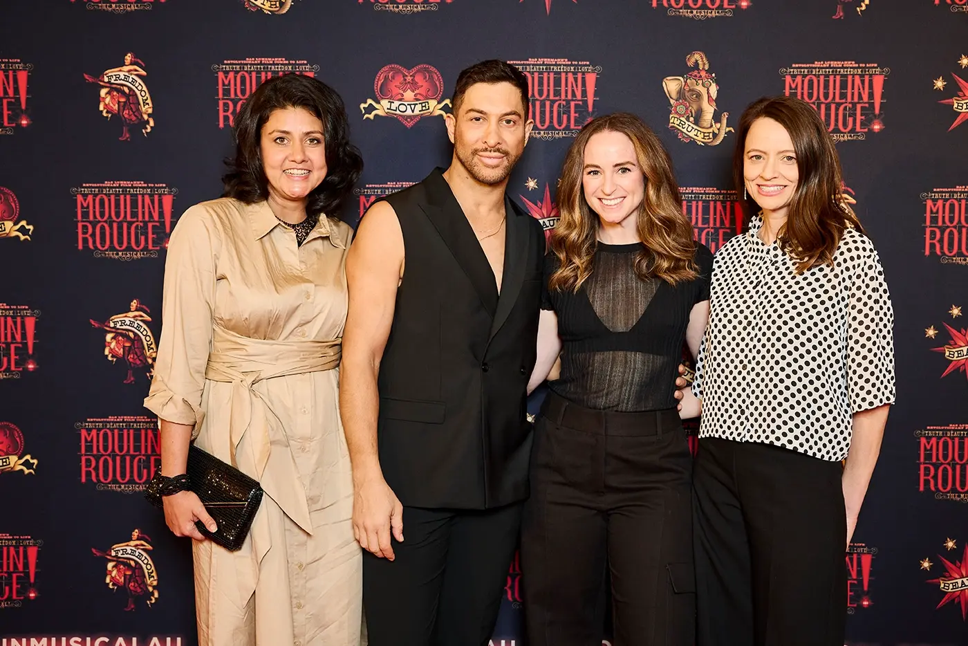The Associate creative team of Moulin Rouge! The Musical Australia posing in front of a media wall at opening night.