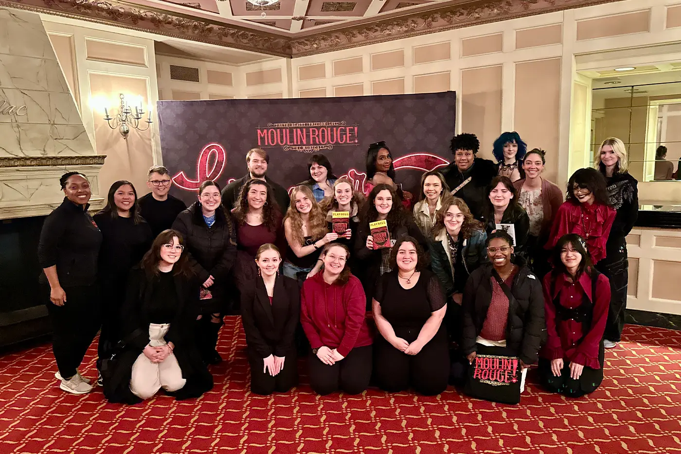 A group of attendees at a Bohemian Project event in the foyer of a theatre