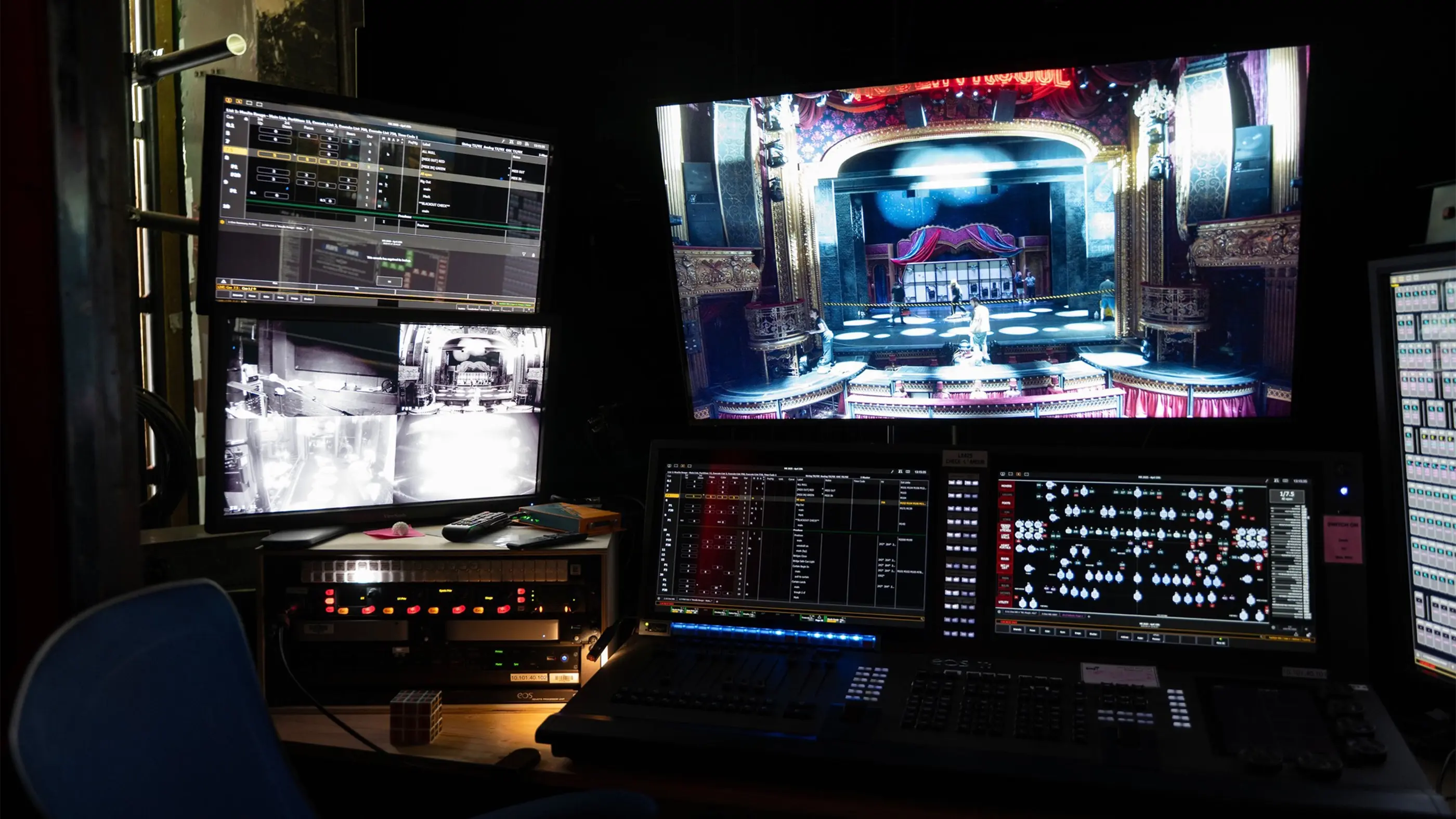 A view of the stage manager's seat backstage at Moulin Rouge! The Musical. Multiple screens display different angles or the show and a sound board sits below.