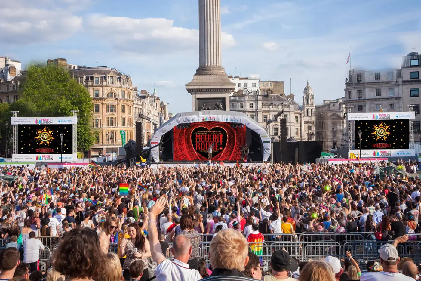 A colourful crowd at West End Pride. The stage shows the Moulin Rouge! The Musical logo.