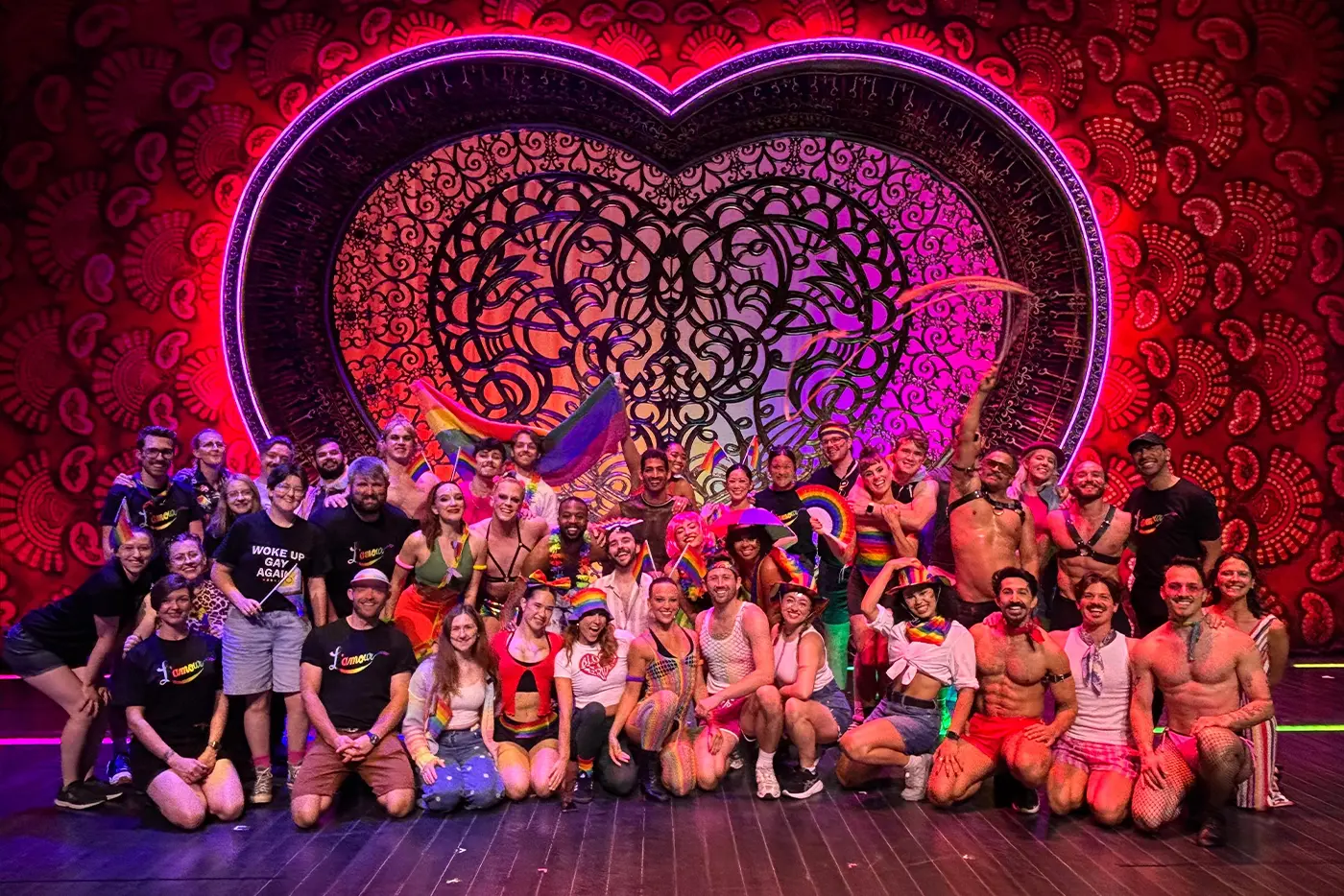 World Tour Moulin Rouge The Musical cast on stage with LGBTQI lighting of the heart portals.