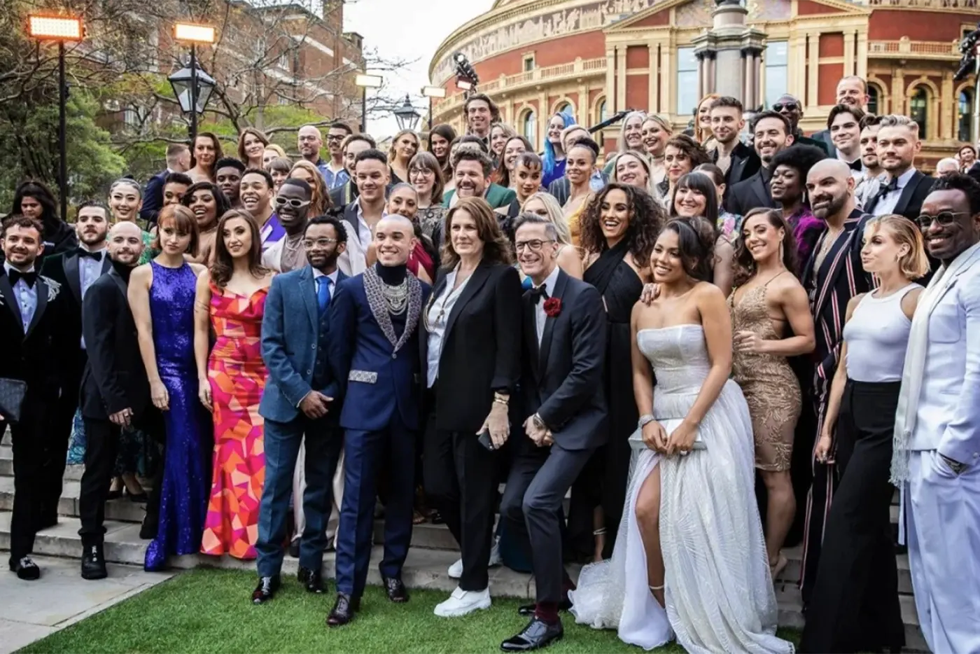 Moulin Rouge! The Musical West End cast and producers posing in formal attire outside before the Olivier Awards ceremony