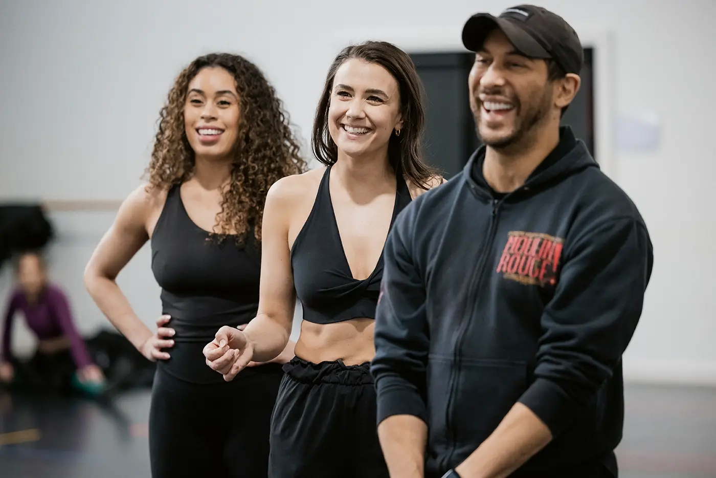 Travis Khan, Resident Choreographer of Moulin Rouge! The Musical Australia, laughing with some of the cast during rehearsal.