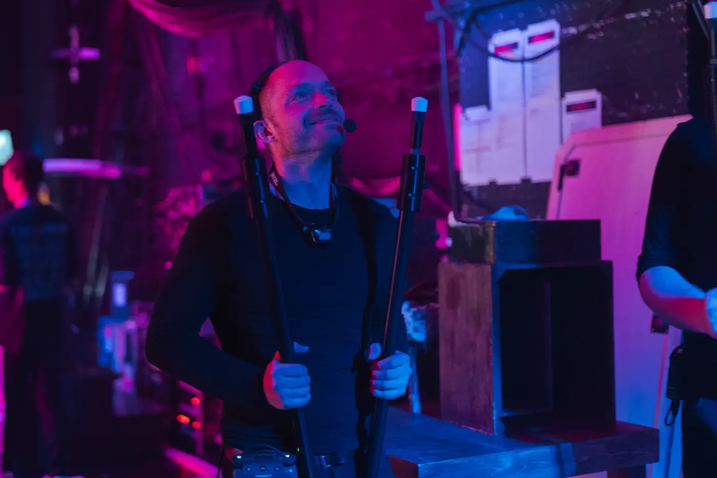 A crew member backstage at Moulin Rouge! The Musical World Tour holding two confetti canes