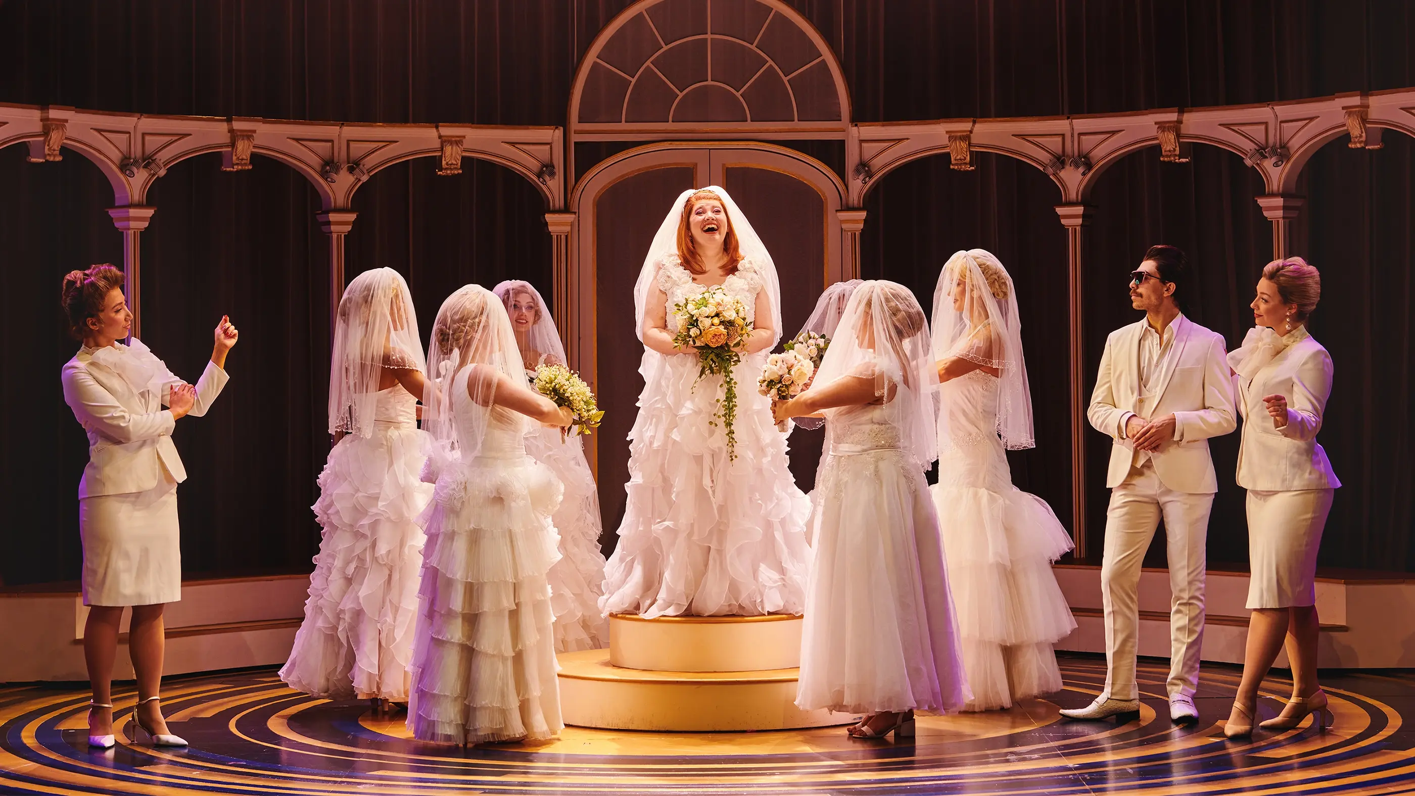 Muriel in a wedding dress on a podium