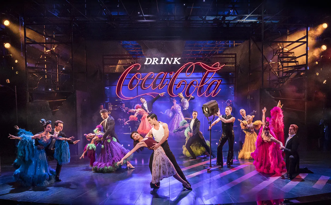 Scott and Fran in front of a big Coca Cola billboard surrounded by couples