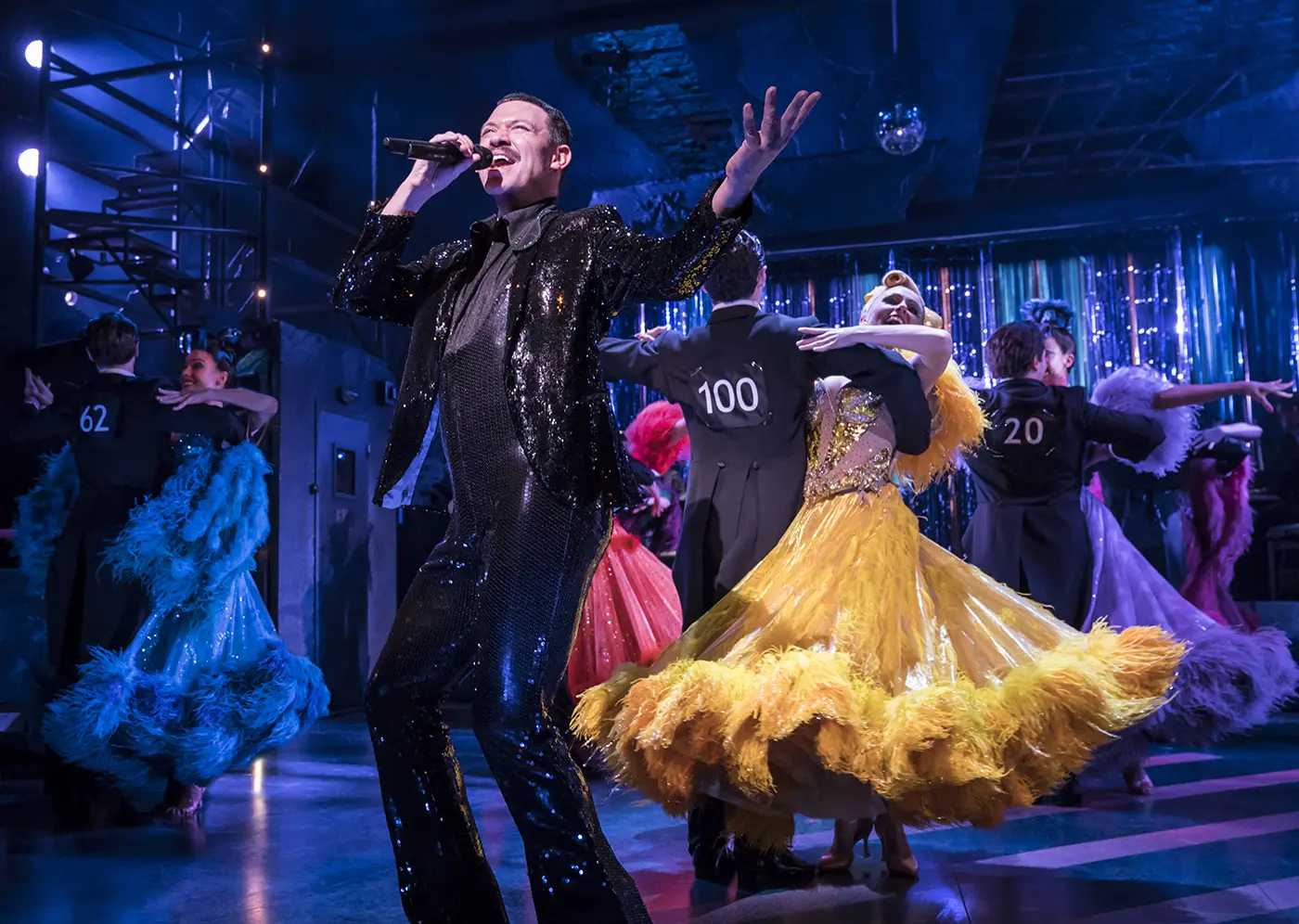 A singer/announcer in front of couples on the dancefloor