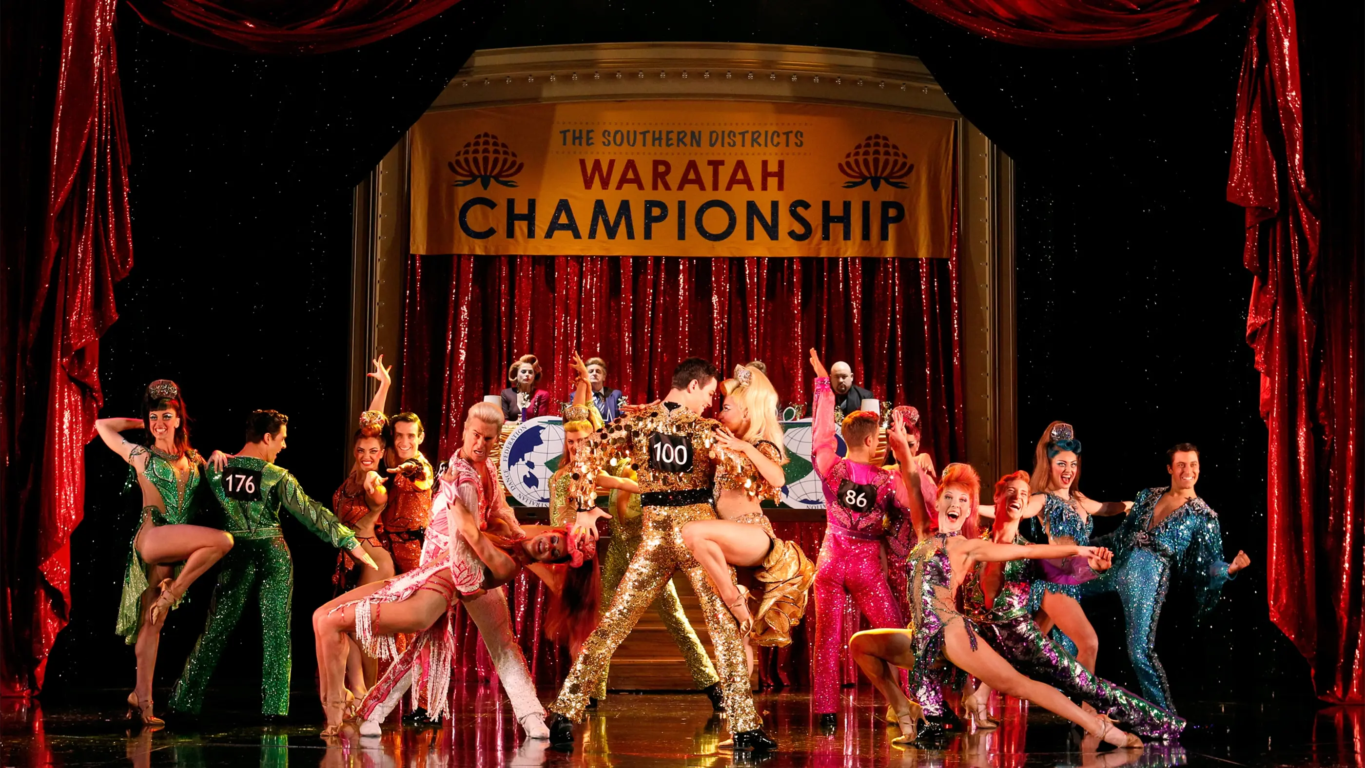 Dance couple 100 in gold sequin matching outfits surrounded by other couple at the Southern Districts Waratah Championship
