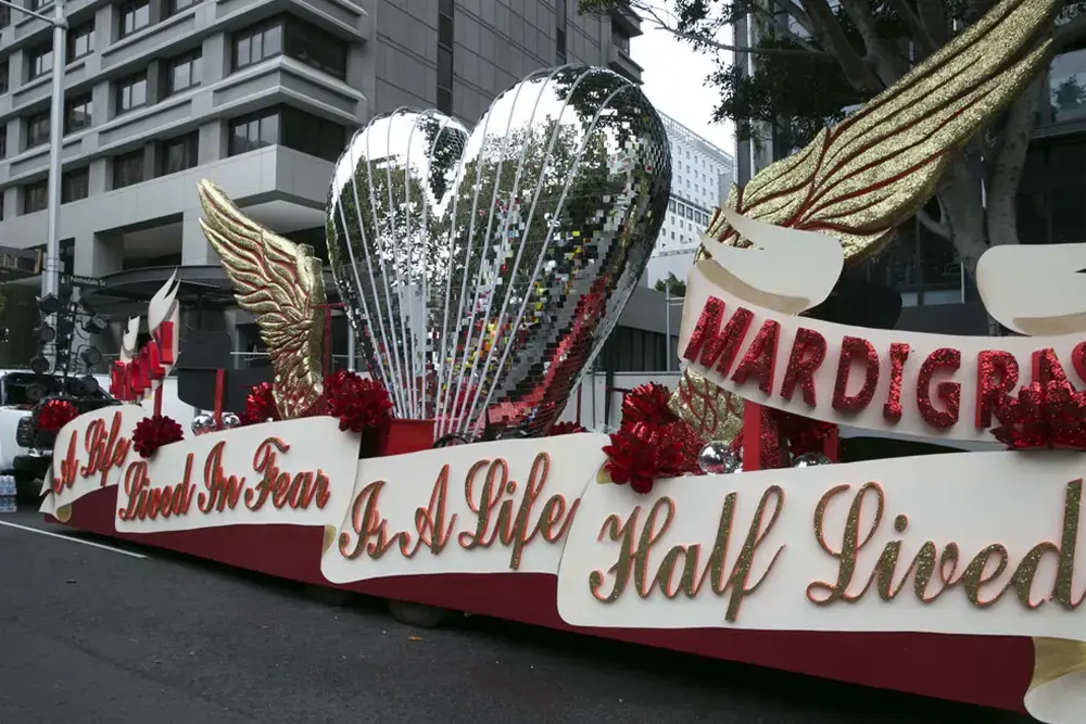 The 2014 Sydney Mardi Gras Strictly Ballroom float. The words A Life Lived In Fear Is A Life Half Lived are written across the float and on top is a big mirror ball style heart with glitter wings.