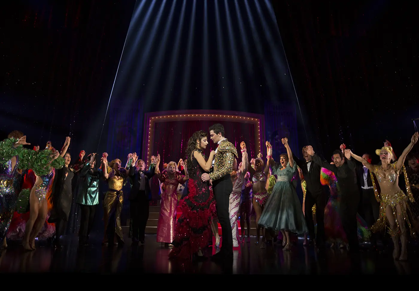 Scott and Fran looking at each other surrounded by the cast holding hands raised in the air