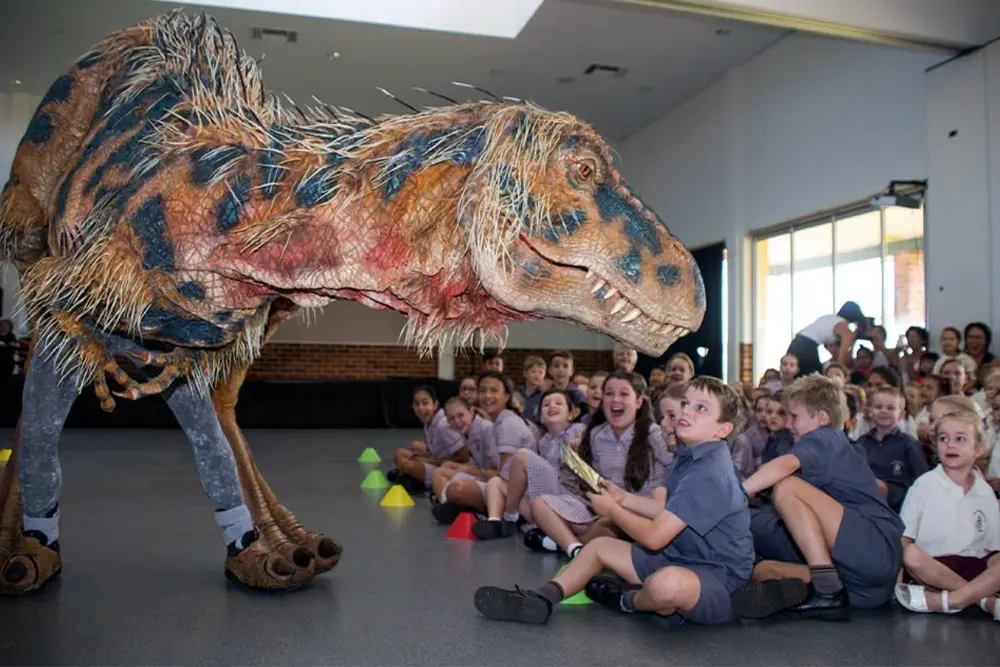 Dinosaur puppet from Walking with Dinosaurs - Arena Spectacular with school students in a classroom