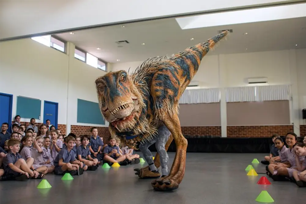 Dinosaur puppet from Walking with Dinosaurs - Arena Spectacular with school students in a classroom