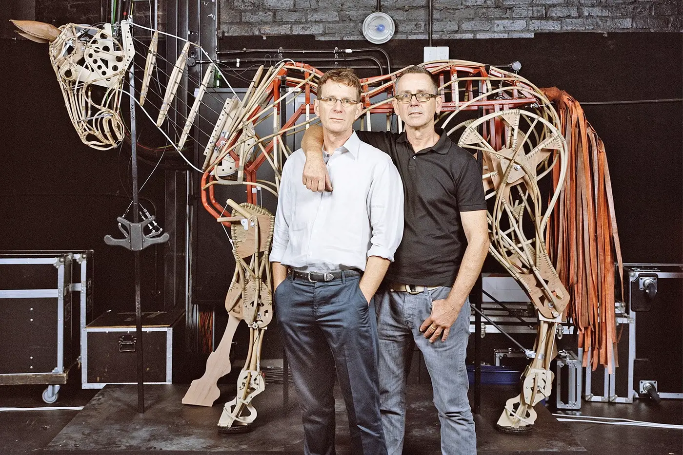 Basil Jones and Adrian Kohler for Handspring Puppet Company standing in front of a horse puppet in process of being built.
