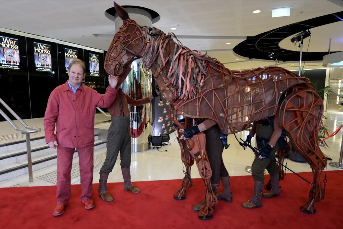War Horse author Michael Morpurgo standing outside Sydney Lyric Theatre with a horse puppet