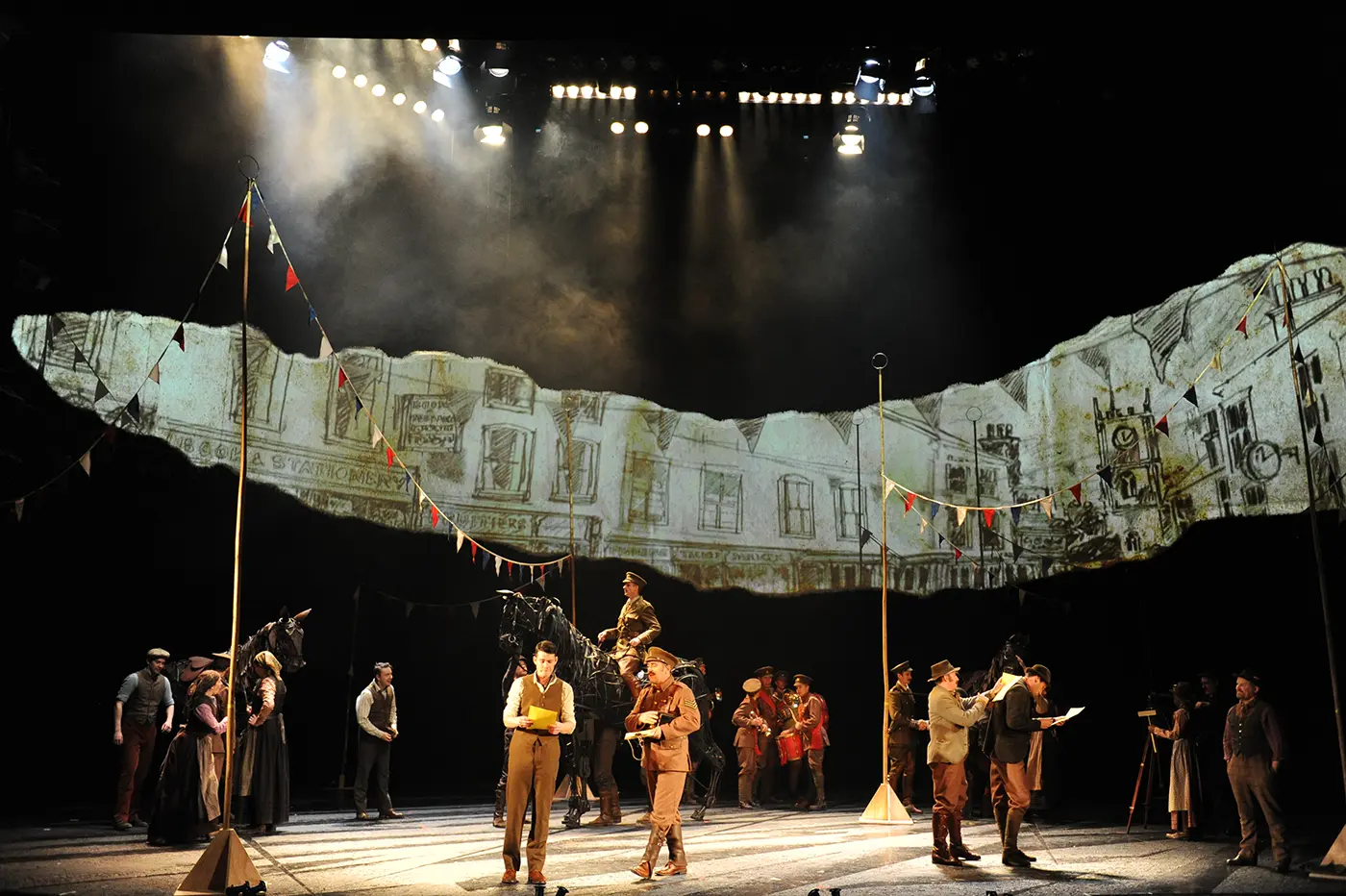 Ensemble scene from War Horse with actors in period costumes.