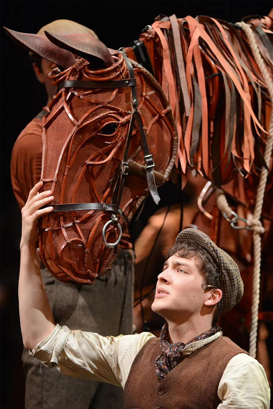 War Horse character Joey sharing a heartfelt moment with his horse puppet on stage.