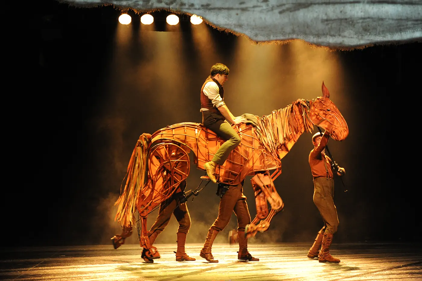 War Horse production scene showing detailed horse puppetry and cast in action.