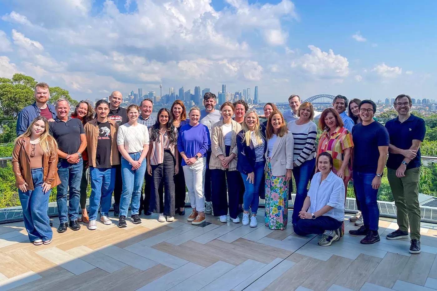 The Global Creatures team at the team summit in 2024 on a balcony at Taronga Zoo over looking the sydney skyline
